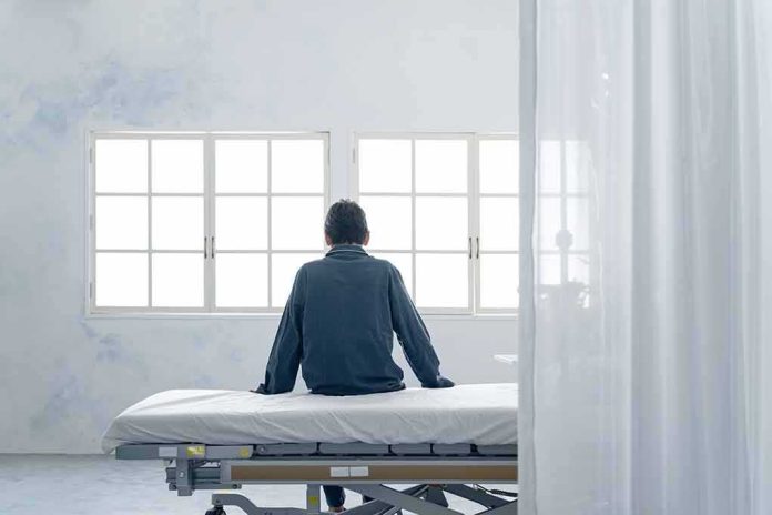 Person sitting on a hospital bed facing bright windows
