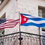 UN Showdown: Cuba Walks, Pressure Mounts American and Cuban flags on a wrought-iron balcony