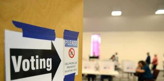 Noncitizen Voting: Tiny Numbers, Big Fight Voting sign on door leading to polling place