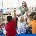 Child Abuse Firestorm – Paris Schools Under Siege Teacher reading to children in a library circle