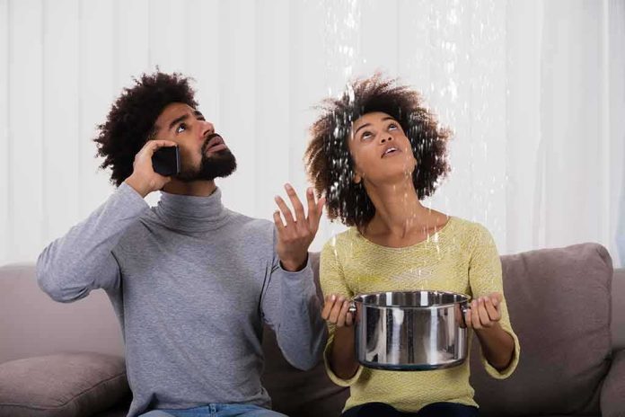 Couple on a couch reacting to water leaking from the ceiling