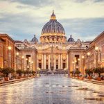 St. Peter's Basilica at the end of a wet street at dusk