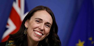 Wizards Meltdown Triggers Rapid Resignation smiling woman at a podium with flags in the background