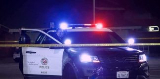 Overdose Money Buys Tahoes, Spy Cameras Police SUV with flashing lights at night behind yellow tape