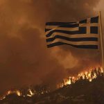 Greek flag over hillside wildfire