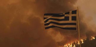 Flames Rip Through – Patriots Hill Flag Stands Greek flag over hillside wildfire