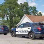 Son Charged With Murdering His Mother Two police SUVs parked near a suburban house