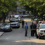 Blood-Soaked Scene – Mom’s Startling Admission Police officers secure a residential street with patrol cars and yellow tape