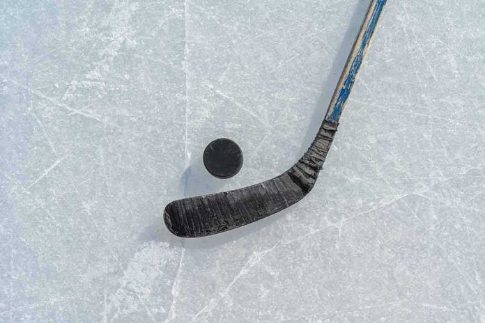 shutterstock_2412305887 Hockey stick and puck on scratched ice