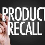 Hand writing product recall on dark background