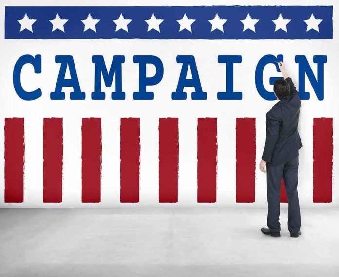 shutterstock_486646441 Man in suit writing on large campaign banner with stars and stripes