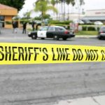 Hollywood Mugging of Actor on Video yellow sheriff's line tape blocks a street near police cars
