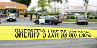Hollywood Mugging of Actor on Video yellow sheriff's line tape blocks a street near police cars